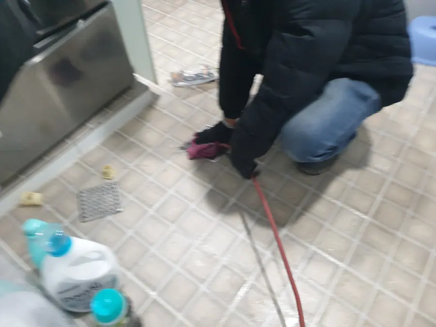 배관 세척을 위해 고압 호스를 다루는 작업자