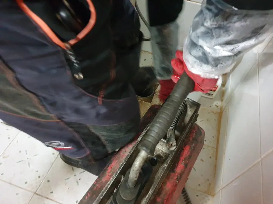 싱크대 하부장 아래에서 작업 도구를 점검하는 기술자